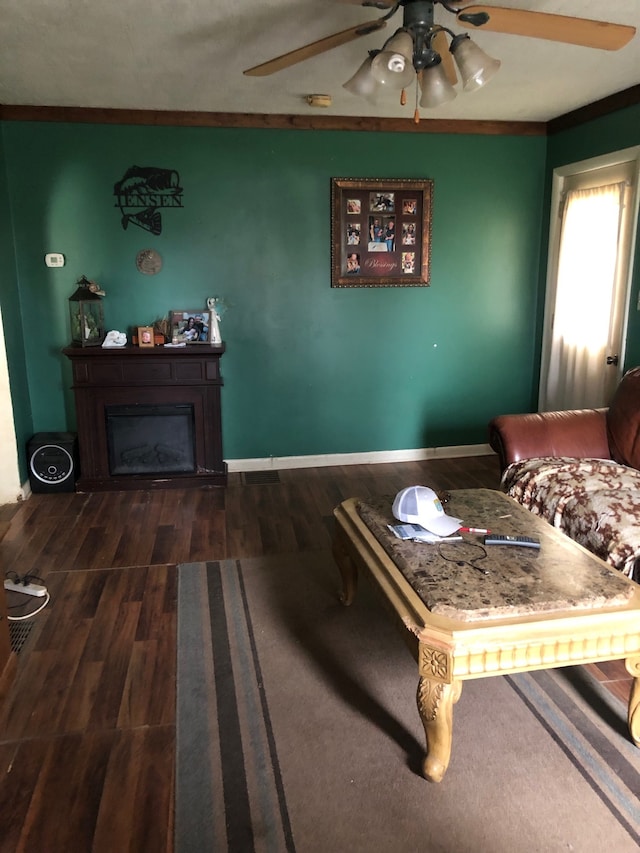 living room featuring ceiling fan and dark wood-type flooring