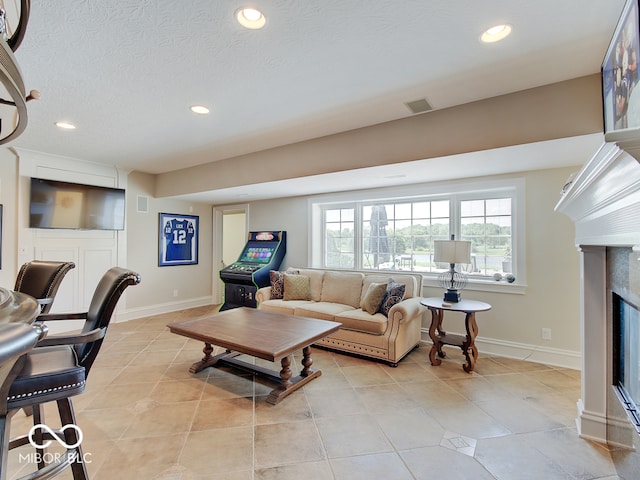 living room featuring a textured ceiling and light tile patterned floors