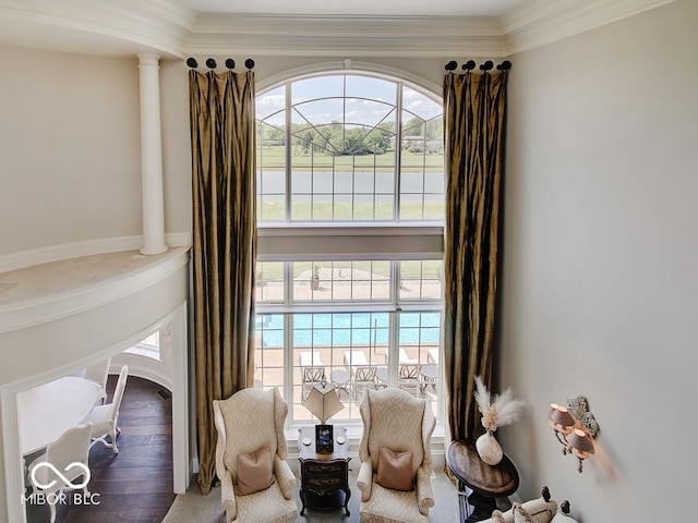 living area featuring decorative columns, ornamental molding, and hardwood / wood-style flooring