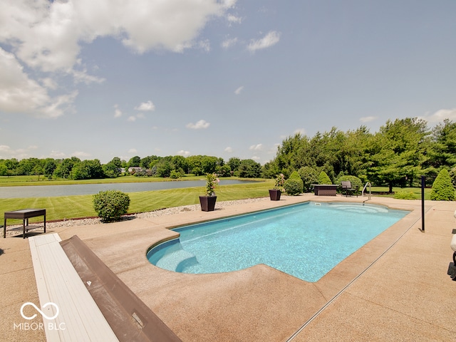 view of pool featuring a patio area, a water view, and a lawn