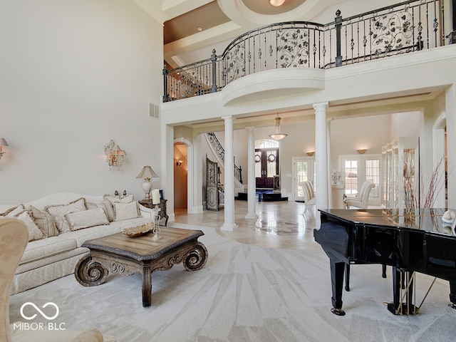 living room featuring light colored carpet, a towering ceiling, and ornate columns