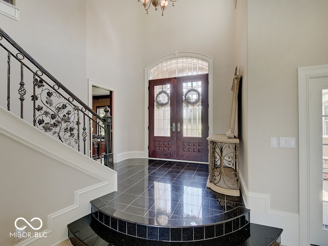 entryway featuring french doors, a notable chandelier, and a high ceiling