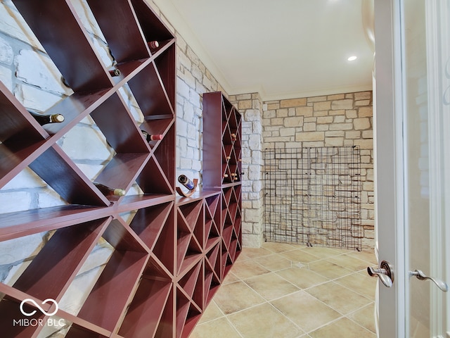 wine area with tile patterned flooring and ornamental molding