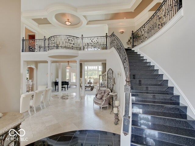 stairway featuring decorative columns, a high ceiling, ornamental molding, coffered ceiling, and tile patterned floors