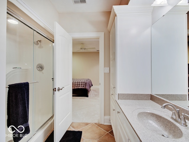 bathroom featuring ceiling fan, vanity, an enclosed shower, and tile patterned flooring