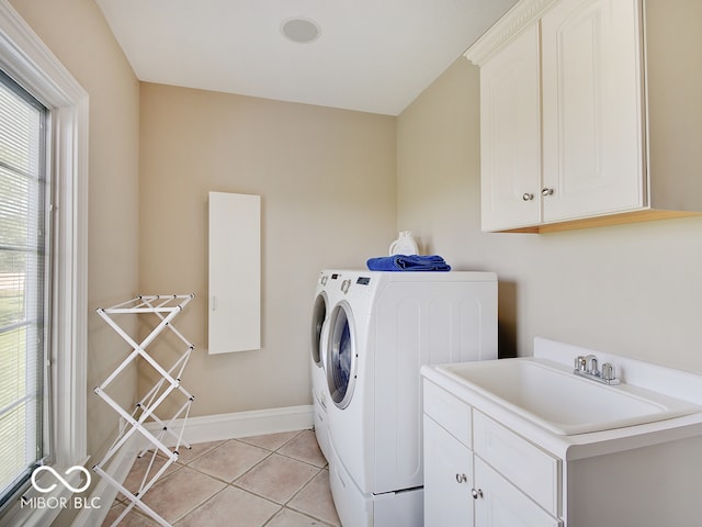 laundry area with sink, washer and clothes dryer, cabinets, and light tile patterned flooring