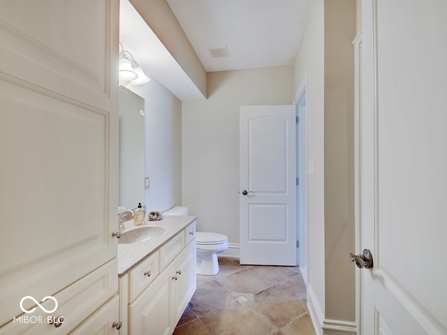 bathroom featuring vanity, tile patterned floors, and toilet