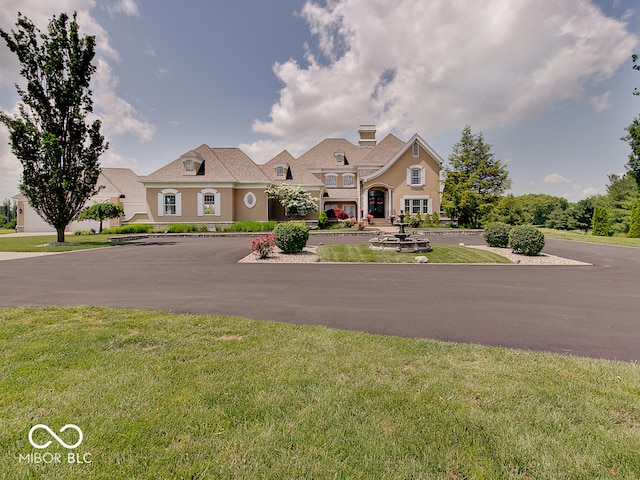 french country inspired facade with a front lawn