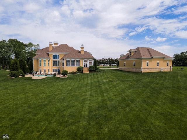 back of house with a yard and a patio