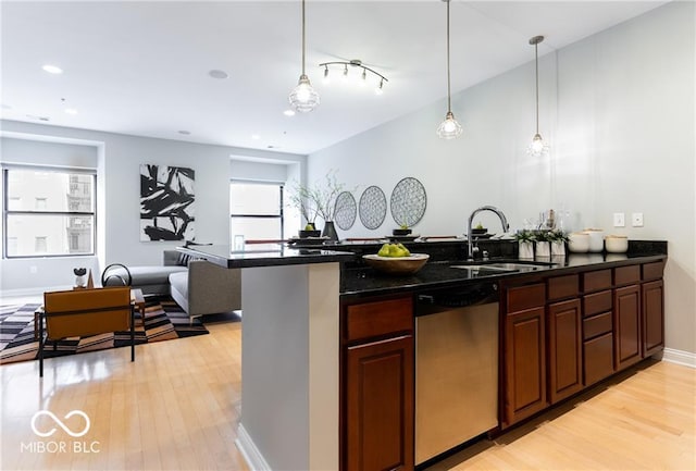 kitchen with light hardwood / wood-style flooring, hanging light fixtures, sink, and dishwasher