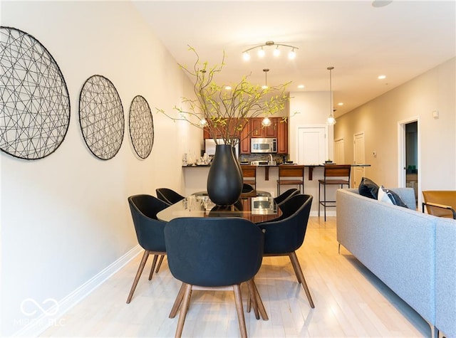 dining room with track lighting and light hardwood / wood-style floors