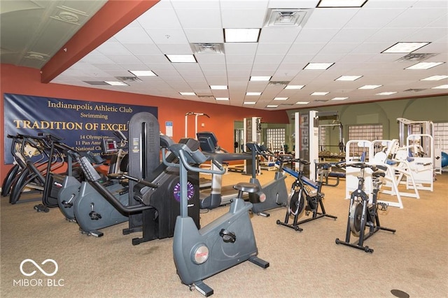 gym featuring light carpet and a paneled ceiling