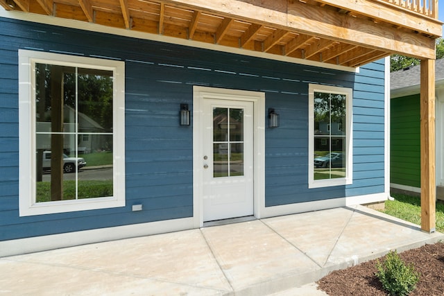 view of exterior entry with a patio