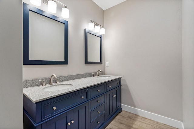 bathroom with oversized vanity, double sink, and wood-type flooring