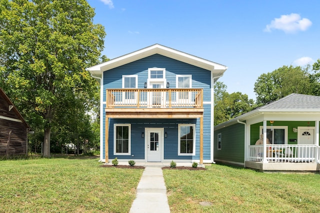 view of front of home featuring a balcony and a front yard