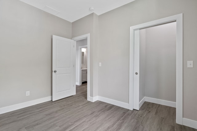 unfurnished bedroom with a closet and wood-type flooring