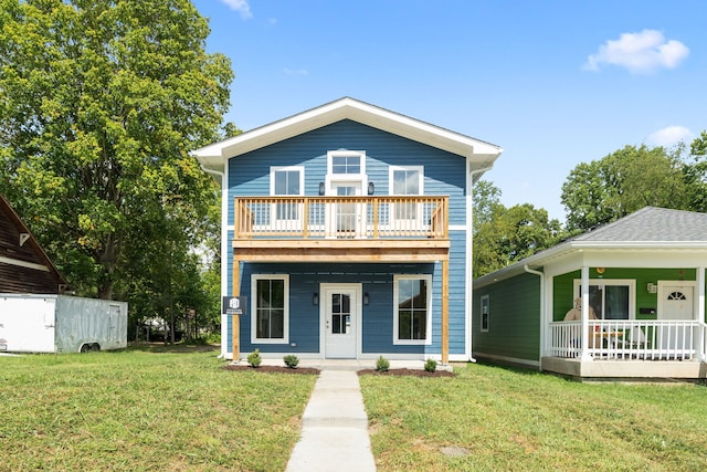 view of front of property featuring a balcony and a front yard