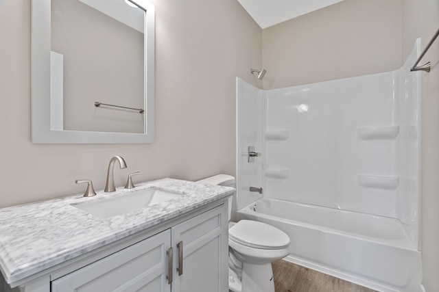 full bathroom with large vanity, toilet, washtub / shower combination, and wood-type flooring