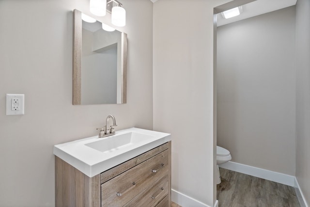 bathroom featuring hardwood / wood-style floors, toilet, and vanity