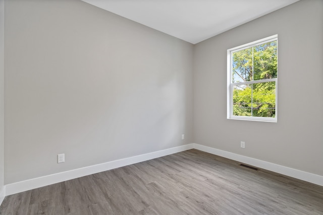 spare room featuring dark hardwood / wood-style floors and plenty of natural light