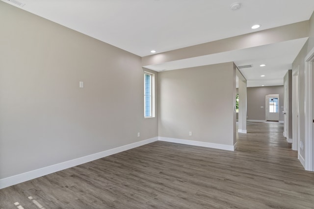 empty room featuring dark wood-type flooring and a wealth of natural light