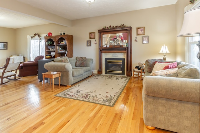 living room with hardwood / wood-style floors, beamed ceiling, plenty of natural light, and a textured ceiling