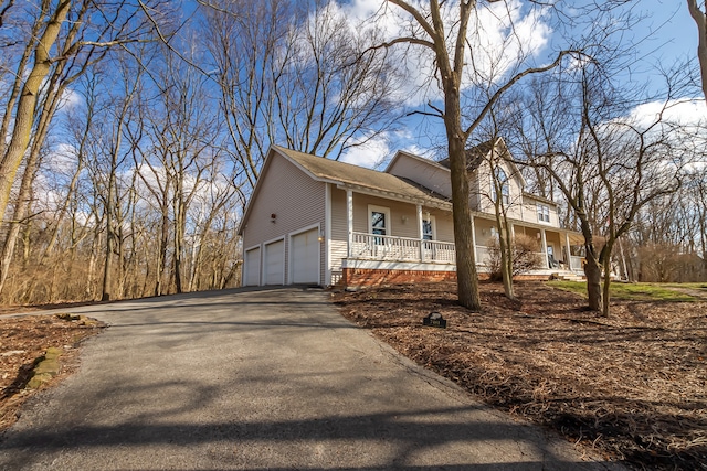 view of property exterior with a porch and a garage