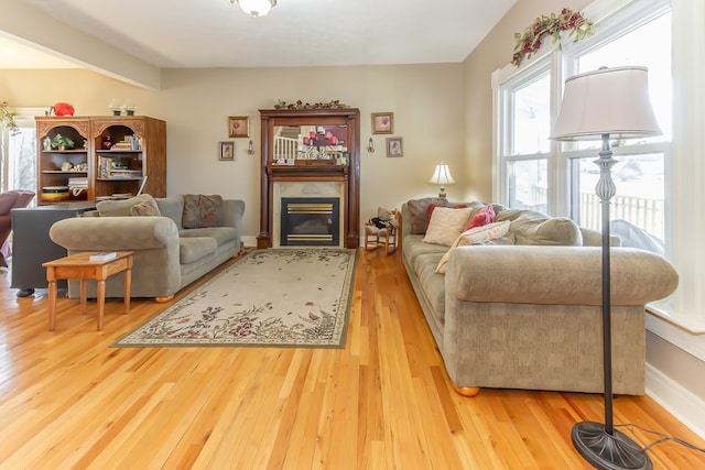 living room with light hardwood / wood-style floors and beam ceiling