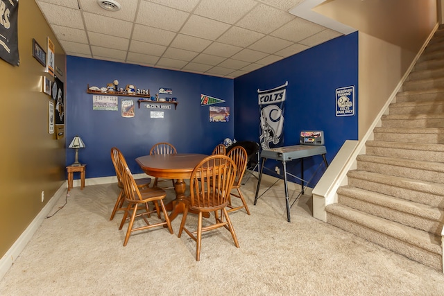 dining space with a drop ceiling and carpet floors