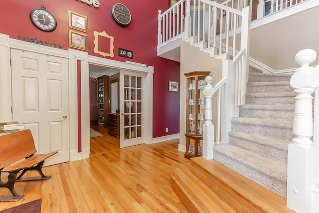 stairway featuring a high ceiling and wood-type flooring