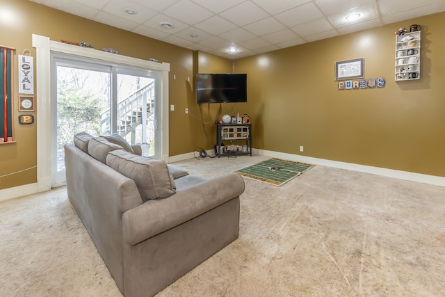 carpeted living room with a drop ceiling