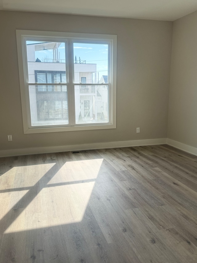 empty room featuring hardwood / wood-style flooring and a healthy amount of sunlight