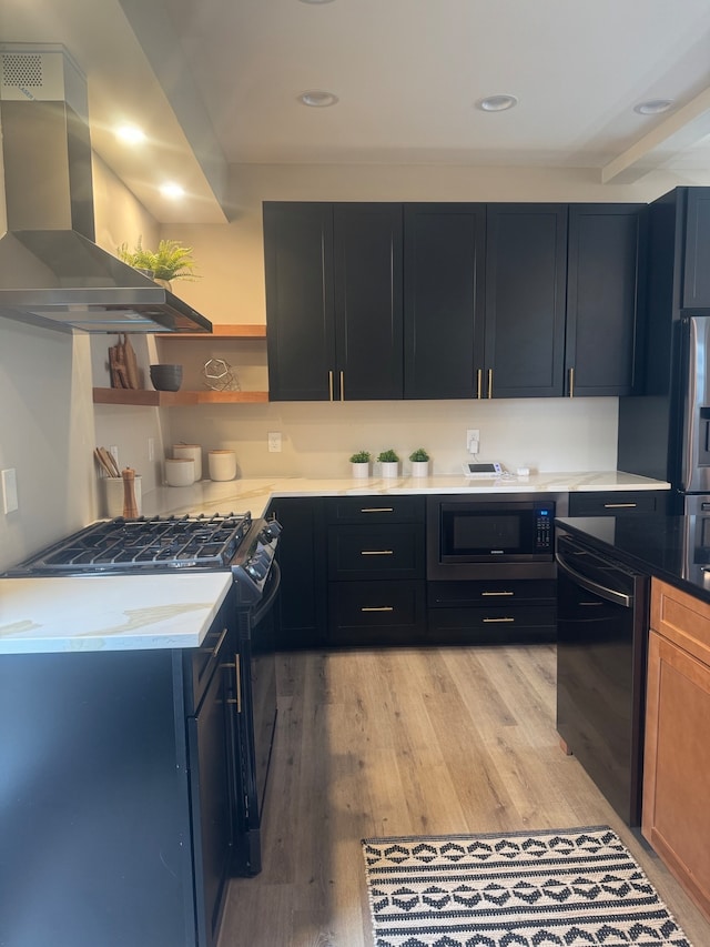 kitchen with light hardwood / wood-style floors, black appliances, and island range hood