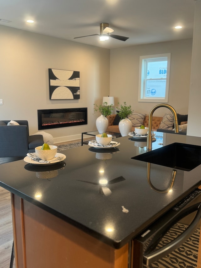 kitchen featuring sink, ceiling fan, and light hardwood / wood-style floors