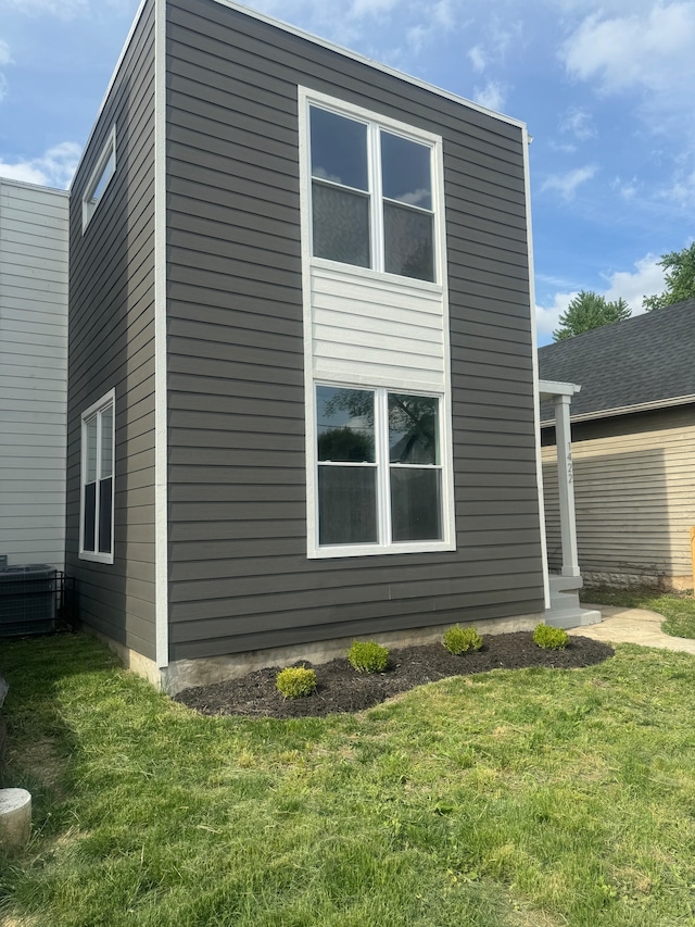 view of home's exterior featuring central air condition unit and a lawn