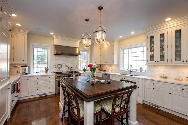 kitchen featuring a center island, dark hardwood / wood-style floors, tasteful backsplash, and wall chimney range hood