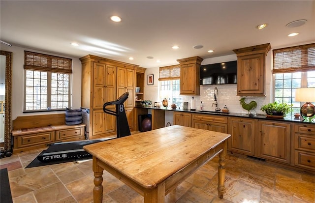 kitchen featuring plenty of natural light, tile flooring, backsplash, and sink