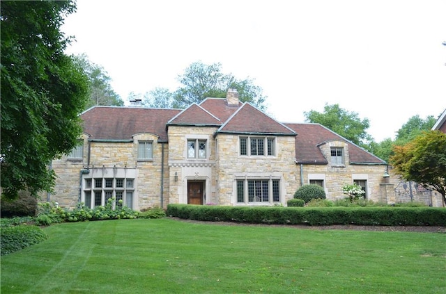 french provincial home with a front yard