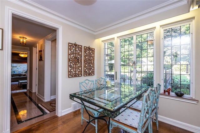 dining space featuring dark hardwood / wood-style flooring, crown molding, plenty of natural light, and french doors