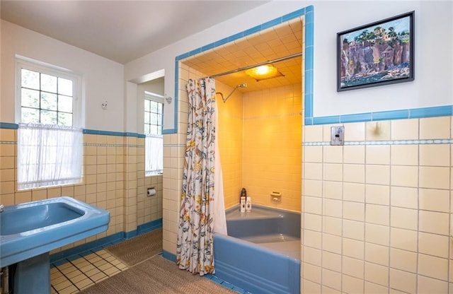 bathroom featuring tile walls, tile floors, and shower / bathtub combination with curtain