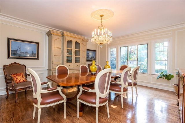 dining room with an inviting chandelier, crown molding, and dark hardwood / wood-style floors