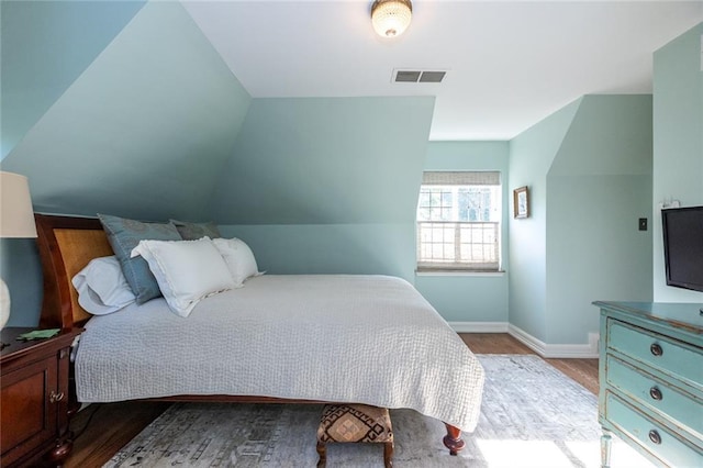 bedroom with lofted ceiling and light wood-type flooring