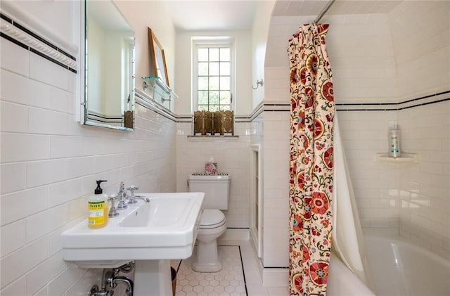 bathroom featuring tile walls, tile floors, toilet, and shower / tub combo