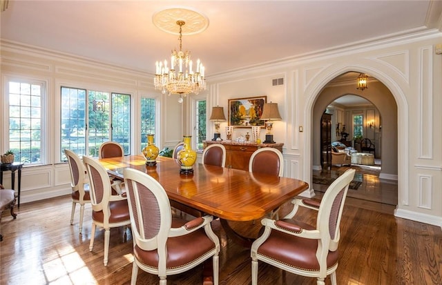 dining room with a chandelier, dark hardwood / wood-style flooring, and ornamental molding