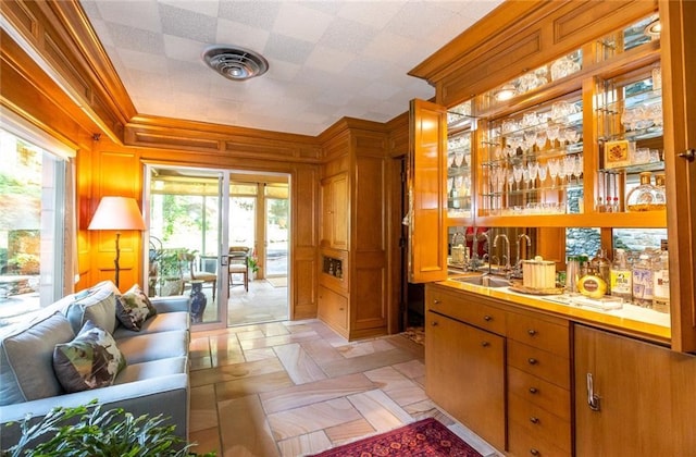 bar featuring light tile floors, sink, tile countertops, and a healthy amount of sunlight