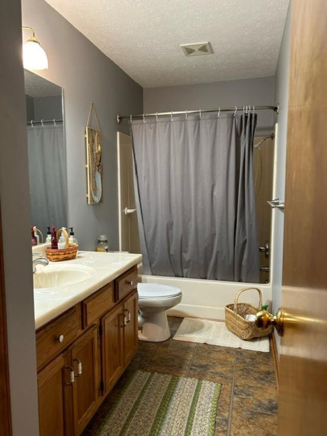 full bathroom featuring a textured ceiling, vanity, toilet, and shower / bath combination with curtain