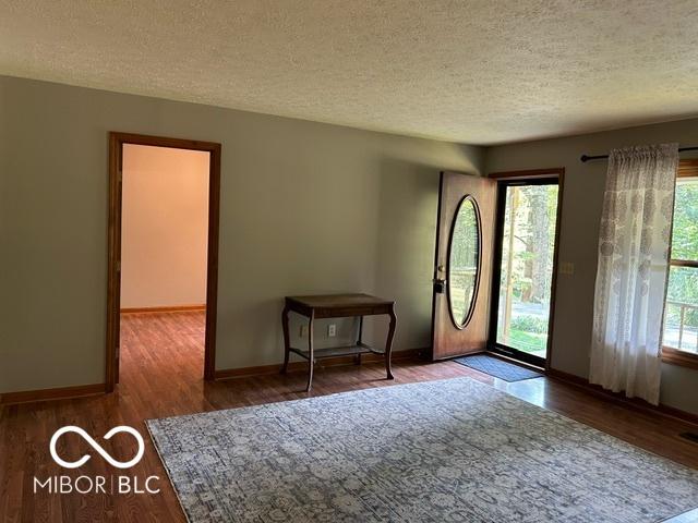 unfurnished room featuring hardwood / wood-style floors and a textured ceiling