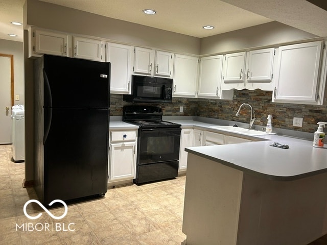 kitchen with black appliances, kitchen peninsula, sink, and white cabinetry