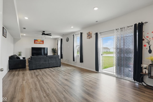living area featuring wood finished floors, ceiling fan, recessed lighting, and baseboards