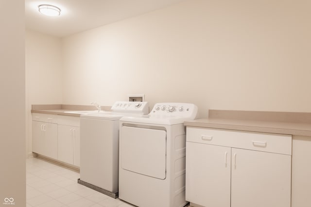 washroom with washer and clothes dryer, cabinets, and sink